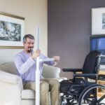 Man using the Advantage Rail to transfer from a living room chair into a wheelchair