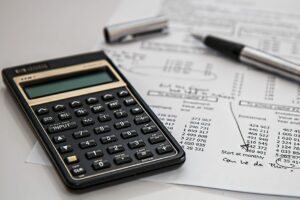 a calculator and pen on top of a piece of paper with numbers on it