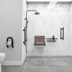 A safe bathroom, with multiple support bars and transfer seat