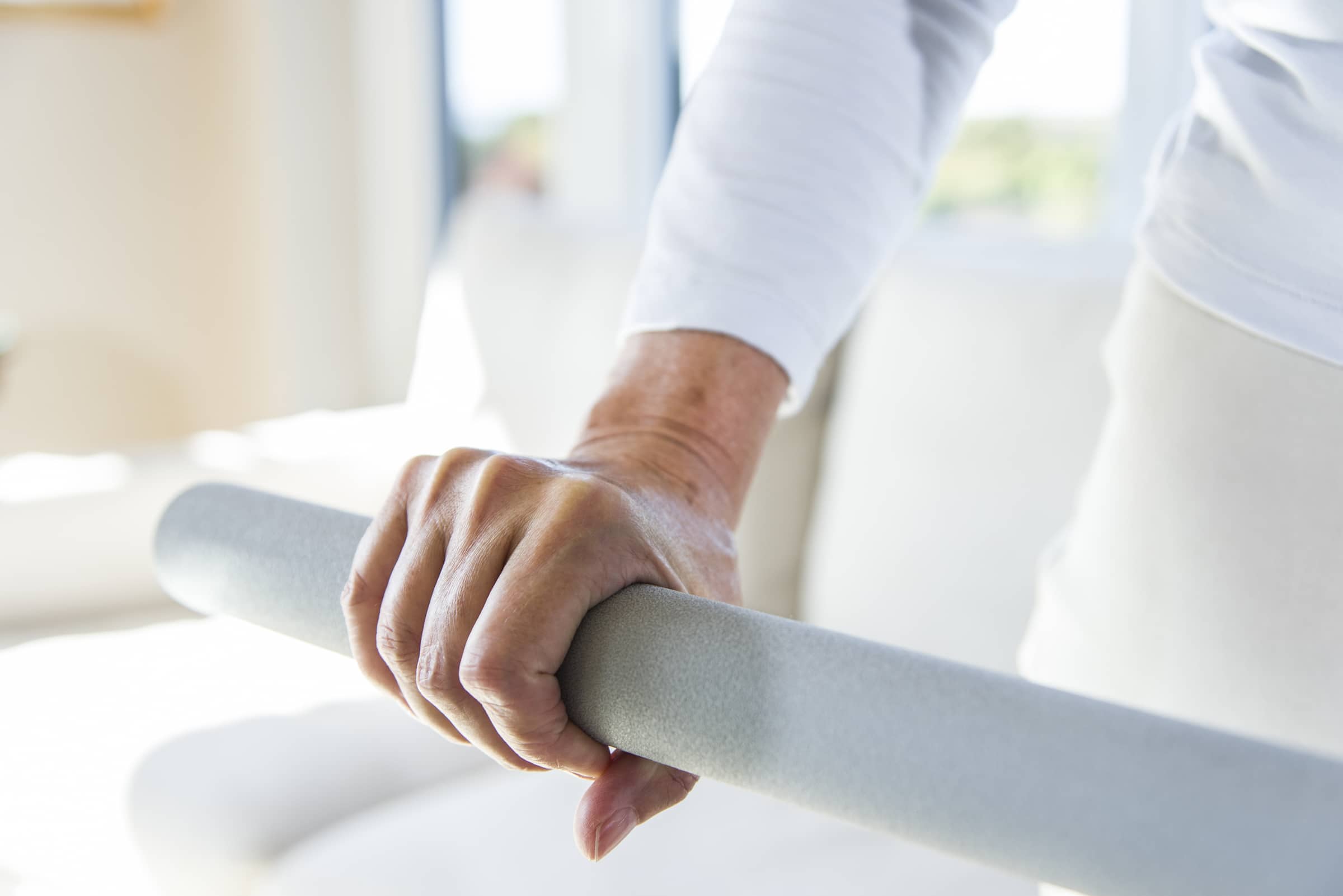A hand holding on to a assistive rail