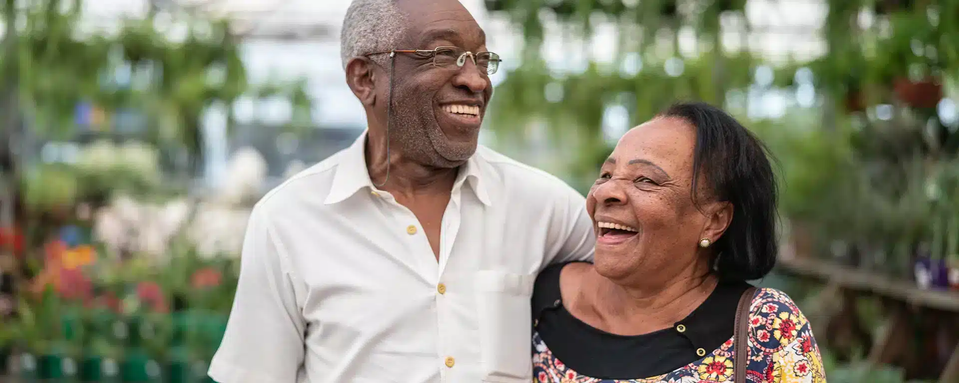 A senior man and woman side by side, smiling together.